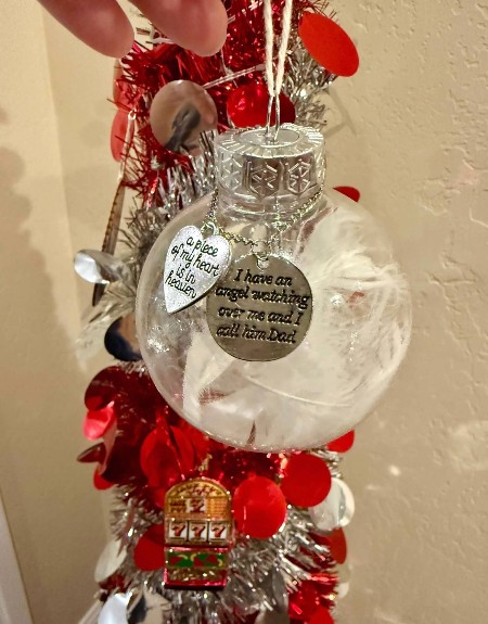 Bright red streams hanging from a clear ball ornament